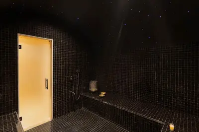 a black tiled bathroom with a white door at Villa Eyline Amelkis Golf in Marrakech