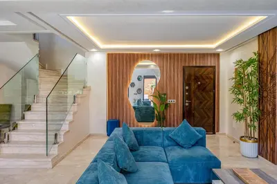a living room with a blue couch and a staircase at Modern Hivernage Duplex with Private pool in Marrakech