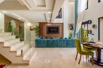 a living room with a blue couch and a table at Modern Hivernage Duplex with Private pool in Marrakech