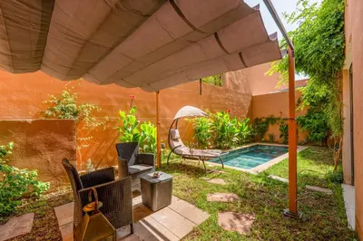 a patio with a pool and an umbrella at Modern Hivernage Duplex with Private pool in Marrakech