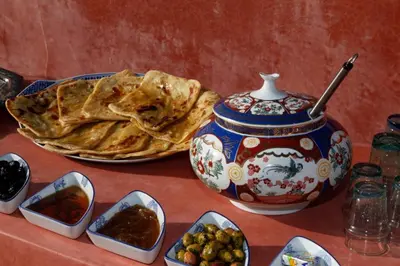 a table with a vase and bowls of food at Boutique Hotel Riad Almoulouk in Marrakech