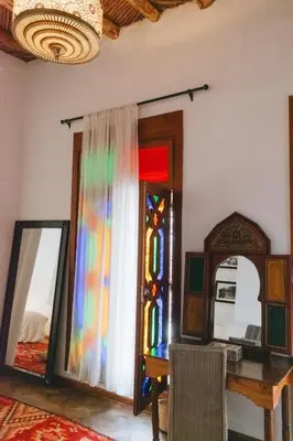 a room with a table and a stained glass window at Boutique Hotel Riad Almoulouk in Marrakech