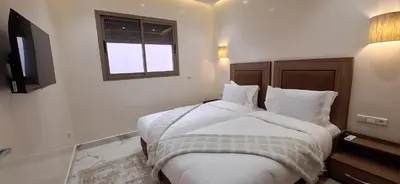 a bedroom with a bed with white sheets and a window at The Elite suites in Marrakech