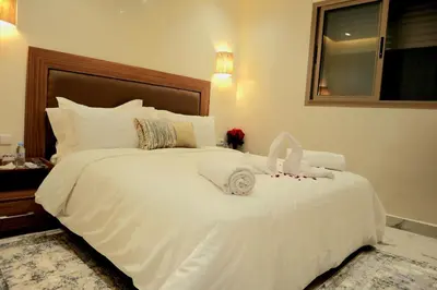 a white bed with towels on it in a bedroom at The Elite suites in Marrakech
