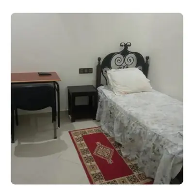 a bedroom with a bed and a desk and a table at Maison D'hôte Dar ALBIDAWI in Marrakech