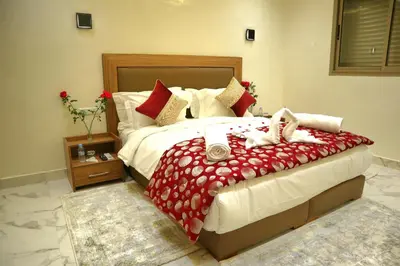 a bedroom with a large bed with red and white sheets at Majestic luxe appartment in Marrakech