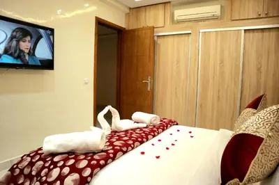 a bedroom with a bed with towels and a flat screen tv at Majestic luxe appartment in Marrakech