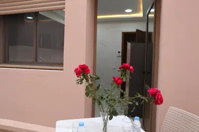 a table with red roses in a vase on it at Majestic luxe appartment in Marrakech