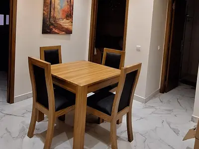 a wooden table and chairs in a room at Majestic luxe appartment in Marrakech