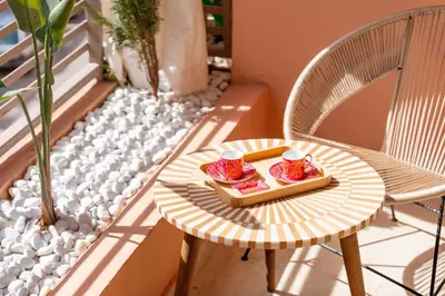 a table and chairs on a balcony with a tray of food at Kasbel 2 Appart & Pool in Marrakech
