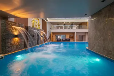 a large swimming pool with water fountains in a building at Kasbel 2 Appart & Pool in Marrakech
