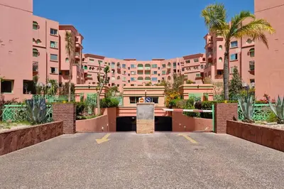 a parking lot in front of a large building at Best location new appart hivernag Pool FreeParking in Marrakech