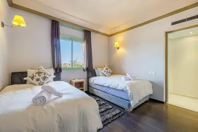 two beds in a room with a window at Best location new appart hivernag Pool FreeParking in Marrakech