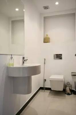 a white bathroom with a sink and a toilet at Appartement De Luxe à Marrakech avec jacuzzi piscine et vue panoramique in Marrakech