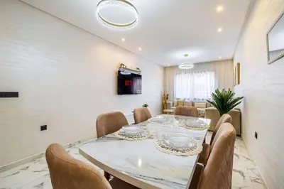 a dining room with a long table and chairs at Family appartment Palmeraie Gate with pool in Marrakech