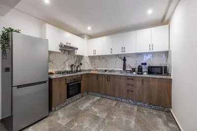 a kitchen with white cabinets and a white refrigerator at Family appartment Palmeraie Gate with pool in Marrakech