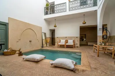 a swimming pool with two pillows in a living room at Riad Nafora in Marrakech