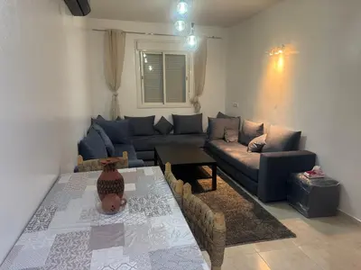 a living room with a couch and a table at Joli appartement nouveau Rez-de-chaussée in Marrakech