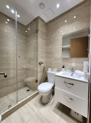 a bathroom with a toilet and a shower and a sink at Appartement Central, vue Piscine-Golf, Lac et Montagne de L'atlas in Marrakech