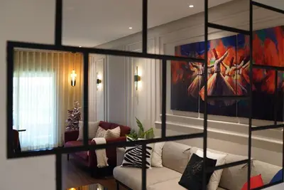 a living room with a couch and a painting on the wall at Appartement Central, vue Piscine-Golf, Lac et Montagne de L'atlas in Marrakech