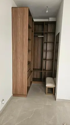 a walk in closet with wooden cabinets and a chair at Villa Dar Maryam in Marrakech