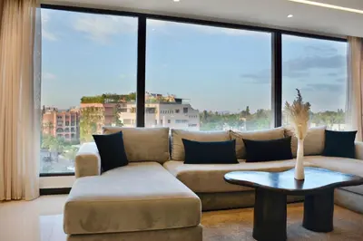 a living room with a couch and a large window at Hevernage penthouse in Marrakech