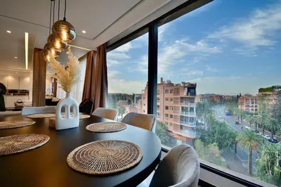 a dining room with a table and a large window at Hevernage penthouse in Marrakech