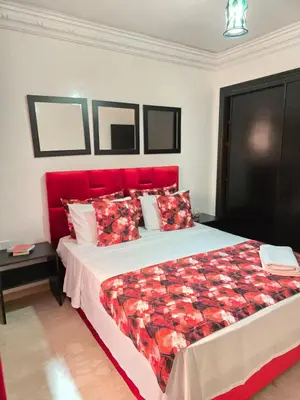 a bedroom with a large bed with a red headboard at Appart de luxe a gueliz a bon prix in Marrakech