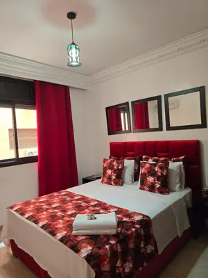 a bedroom with a large bed with a red headboard at Appart de luxe a gueliz a bon prix in Marrakech