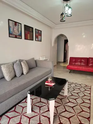 a living room with a couch and a red chair at Appart de luxe a gueliz a bon prix in Marrakech