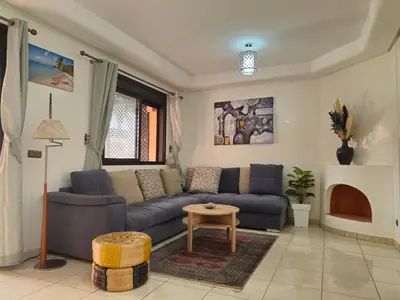 a living room with a couch and a table at Appartement élégant près du stade in Marrakech