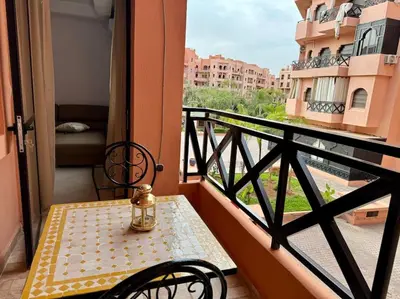 a table and chairs on a balcony with a view at Appartement élégant près du stade in Marrakech