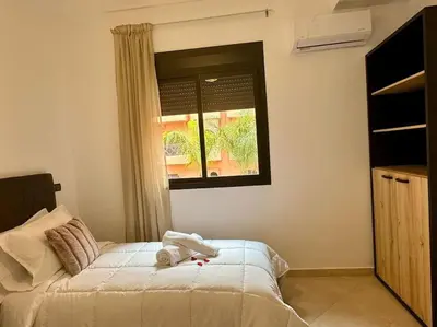 a bedroom with a bed and a window at Appartement élégant près du stade in Marrakech