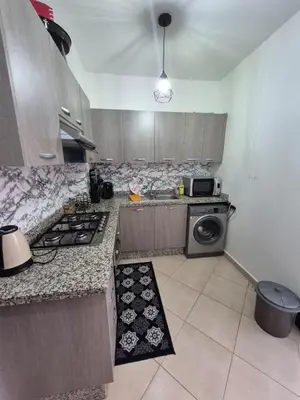 a kitchen with a stove and a washing machine at Appartement élégant près du stade in Marrakech