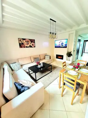 a living room with a couch and a table at Appartement élégant près du stade in Marrakech