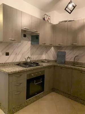a kitchen with wooden cabinets and a stove top oven at Séjour Étoilé in Marrakech