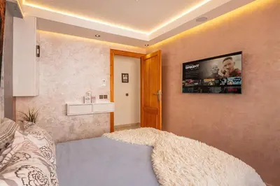 a bedroom with a bed and a tv on the wall at Modern New Appartement Fully Equiped In Center of guéliz in Marrakech