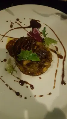 a white plate with a piece of food with sauce at Riad Maialou & SPA in Marrakech