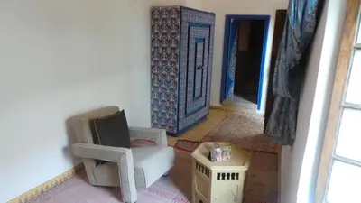a living room with a chair and a door at Riad Maialou & SPA in Marrakech