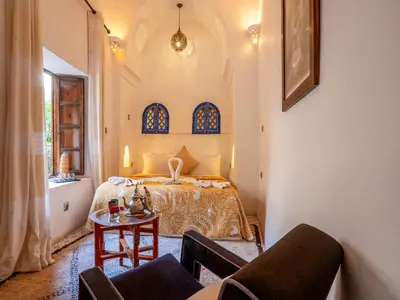a bedroom with a bed and a table at Riad Maialou & SPA in Marrakech