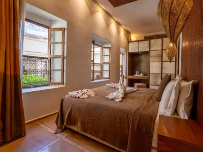 a bedroom with a bed with towels on it at Riad Maialou & SPA in Marrakech