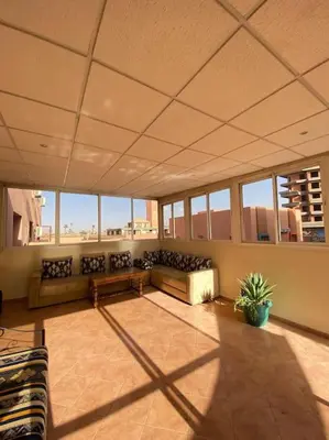 a large living room with couches and a table at Superbe Appartement avec Véranda et Terrasse in Marrakech
