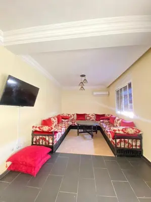 a living room with a couch and a flat screen tv at Superbe Appartement avec Véranda et Terrasse in Marrakech