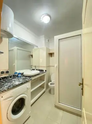 a bathroom with a washing machine and a toilet at Superbe Appartement avec Véranda et Terrasse in Marrakech