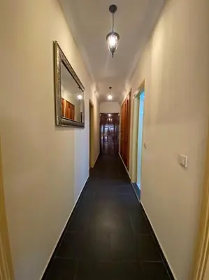 a hallway with a mirror and a long hallway with a hallwayngthngthngthngth at Superbe Appartement avec Véranda et Terrasse in Marrakech