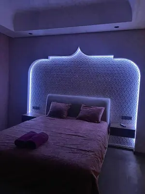 a bedroom with a large bed with a blue lighting at villa de luxe avec piscine privée in Marrakech
