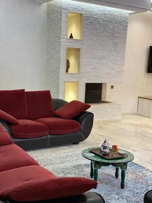 a living room with a red couch and a table at villa de luxe avec piscine privée in Marrakech