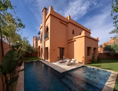 a villa with a swimming pool in front of a house at Villa Leya - Piscine chauffée in Marrakech