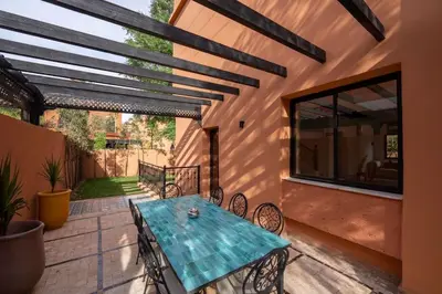 a patio with a turquoise table and chairs at Villa Leya - Piscine chauffée in Marrakech