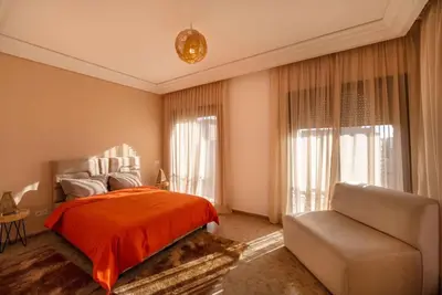 a bedroom with a bed and a couch at Villa Leya - Piscine chauffée in Marrakech